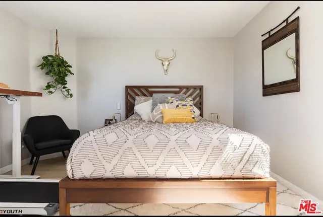a bedroom with a bed and a potted plant
