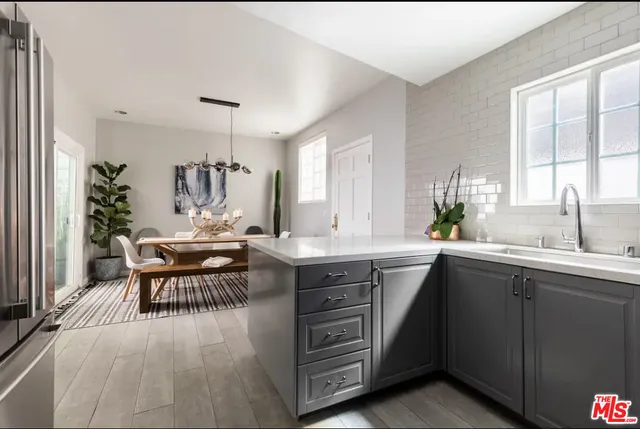 a kitchen with a table chairs and wooden floor