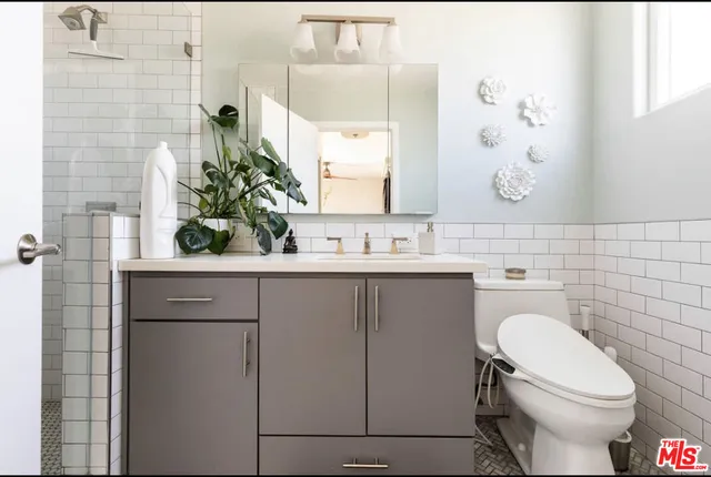 a bathroom with a sink a toilet and mirror