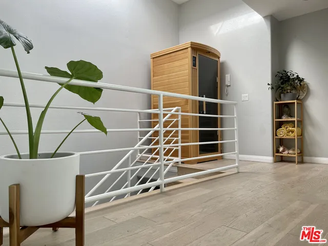 a view of an empty room with wooden floor and windows
