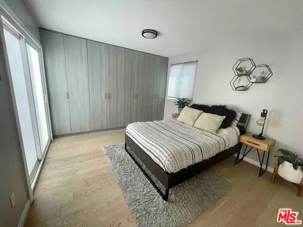 a bedroom with a bed and painting on the wall