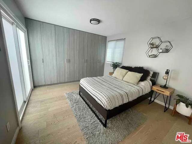 a bedroom with a bed and painting on the wall