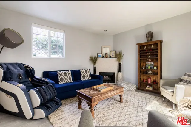 a living room with furniture a rug and a window