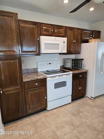 a kitchen with stainless steel appliances granite countertop a refrigerator a stove a sink and a microwave