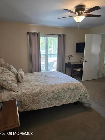 a bedroom with a bed and a flat tv screen on dresser