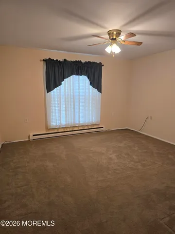 an empty room with a ceiling fan and window