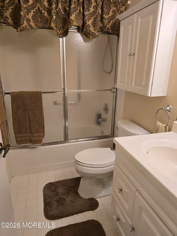 a bathroom with a granite countertop toilet sink and mirror