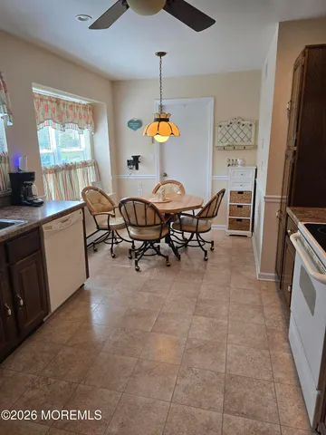 a dining room with furniture a chandelier and window