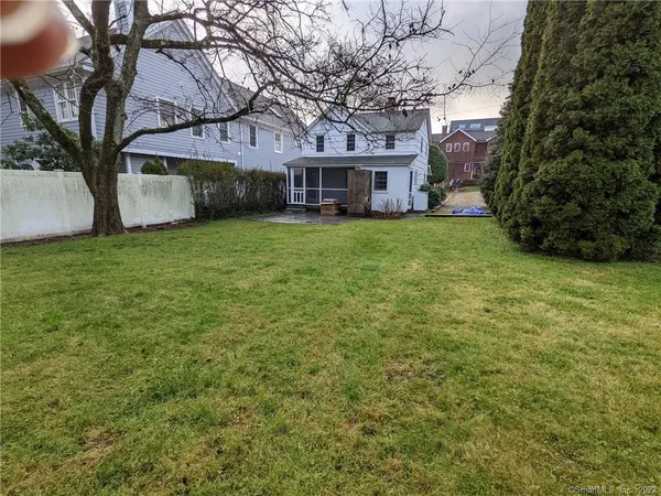 a front view of a house with a garden and trees
