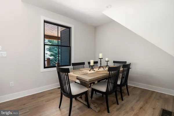 a kitchen with stainless steel appliances granite countertop a table chairs sink refrigerator and cabinets