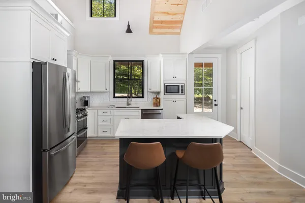 a kitchen with white cabinets and stainless steel appliances