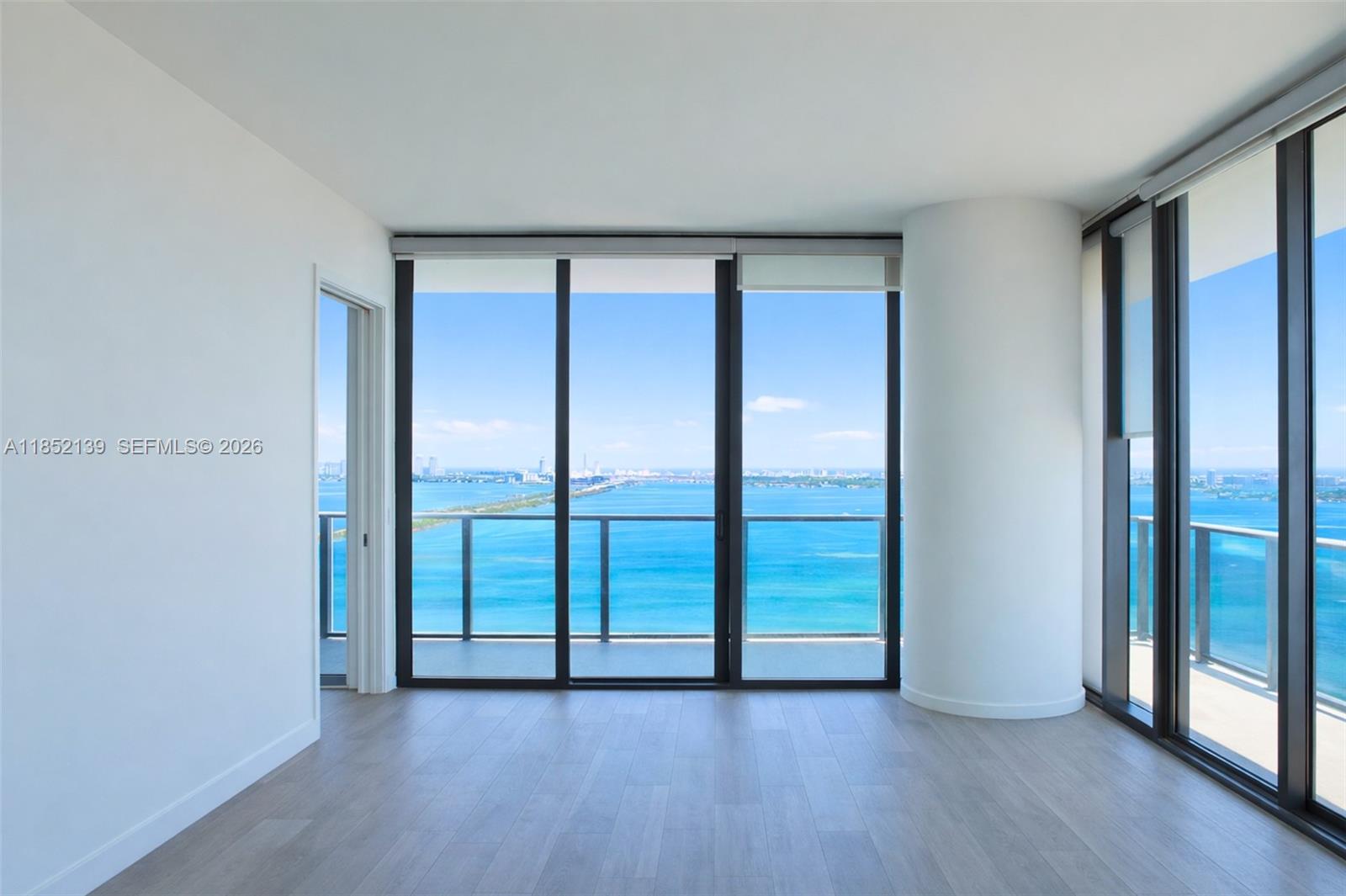 480 Northeast 31st Street, Unit 3301 Miami, FL 33137 - Photo 1 of 32 an empty room with wooden floor and sliding door