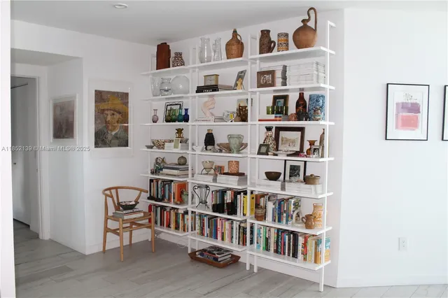 a living room with lots of books and a shelf