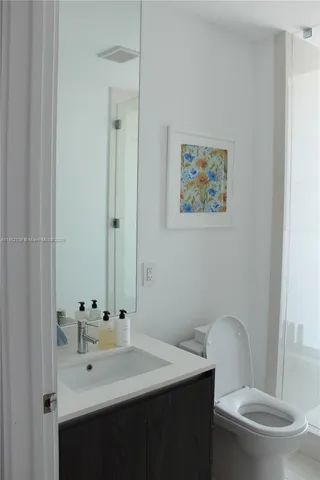 a bathroom with a sink mirror vanity and toilet
