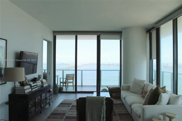 a living room with furniture and a floor to ceiling window
