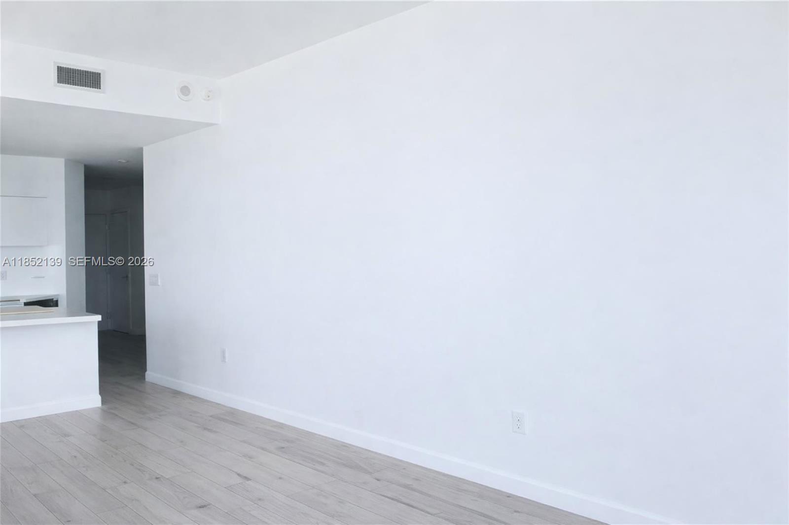 480 Northeast 31st Street, Unit 3301 Miami, FL 33137 - Photo 5 of 32 a view of an empty room with wooden floor and a window