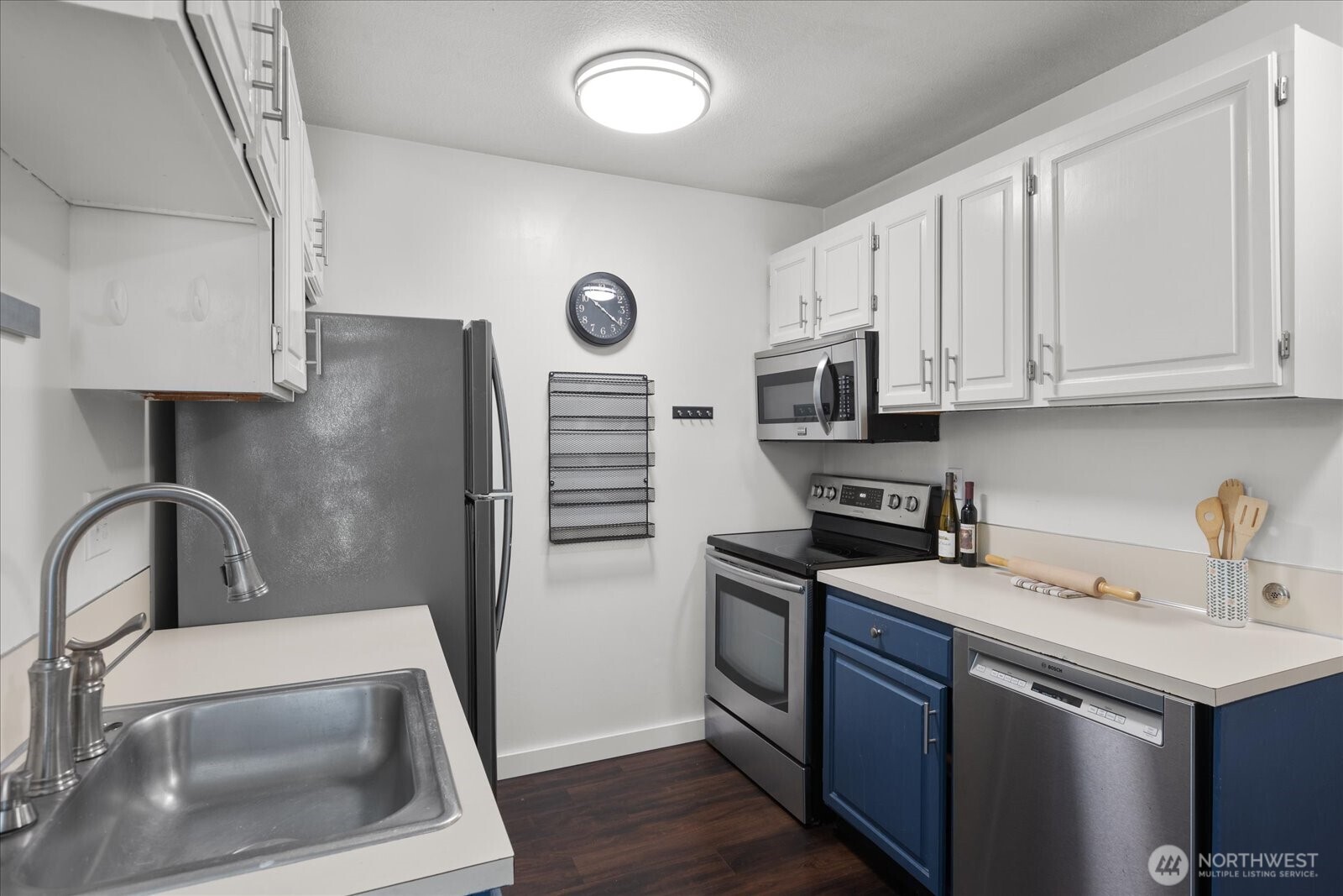 3024 Northeast 143rd Street, Unit 305 Seattle, WA 98155 - Photo 11 of 17 a kitchen with a sink a stove a microwave and cabinets