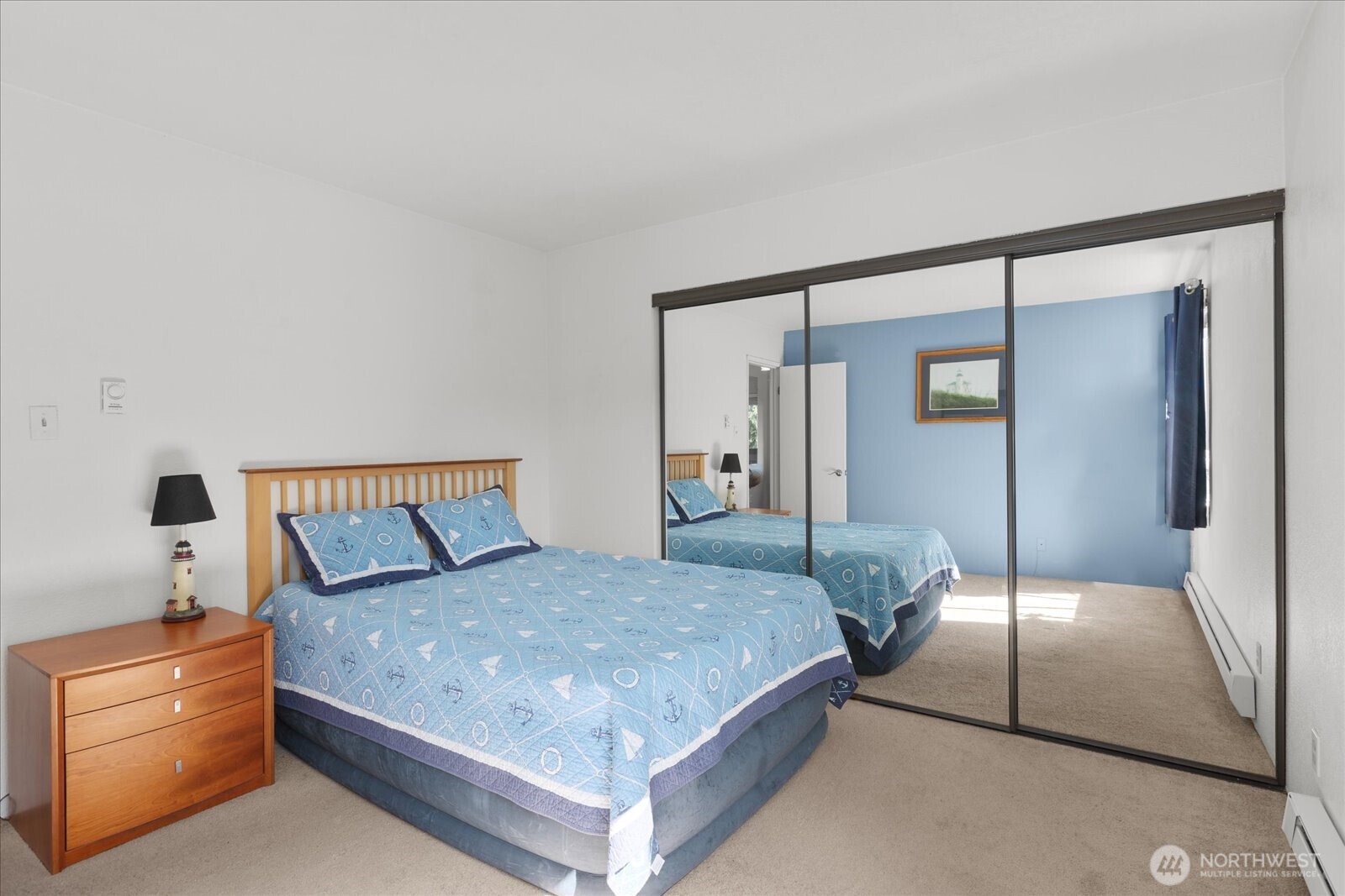 3024 Northeast 143rd Street, Unit 305 Seattle, WA 98155 - Photo 9 of 17 a bedroom with a large bed and a lamp on table