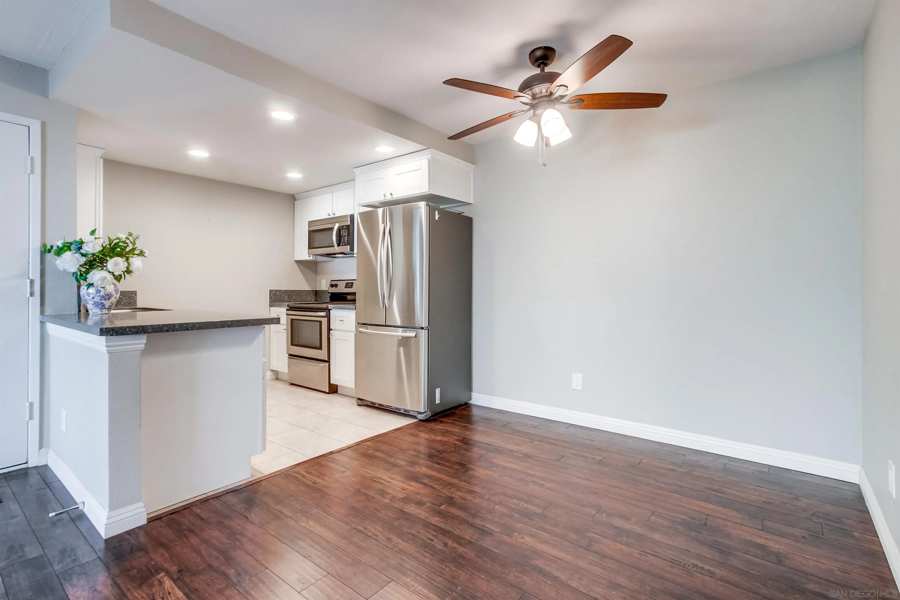 5970 Rancho Mission Road, Unit 241 San Diego, CA 92108 - Photo 8 of 26 a kitchen with granite countertop a refrigerator and a stove top oven