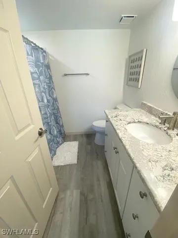 a spacious bathroom with a granite countertop sink and a mirror