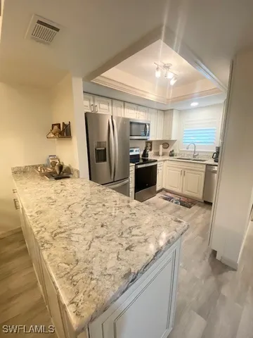a large kitchen with kitchen island granite countertop a sink stove and refrigerator