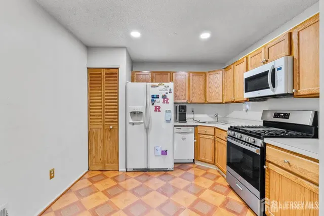 a kitchen with stainless steel appliances granite countertop a stove a sink and a refrigerator