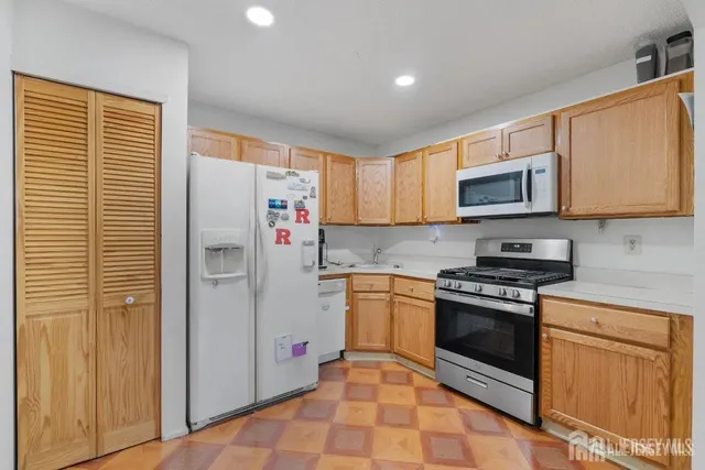 a kitchen with stainless steel appliances granite countertop a stove a refrigerator and a microwave