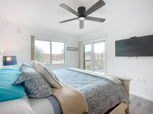 a bedroom with a large bed and a flat tv screen on dresser