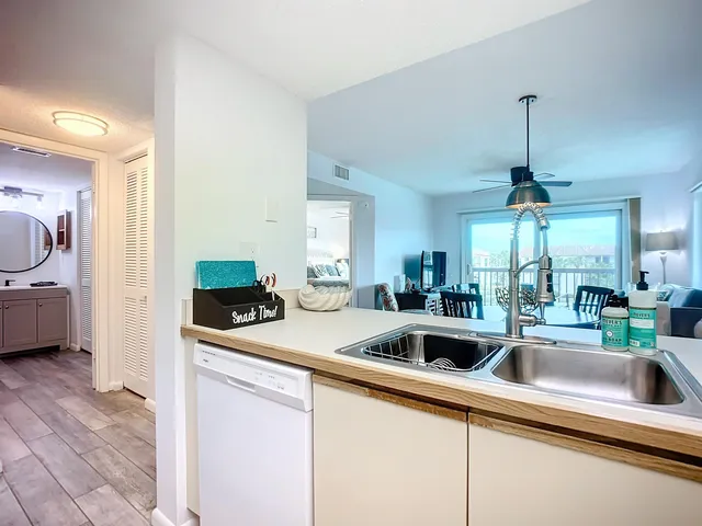 a kitchen that has a sink and a stove with white countertops