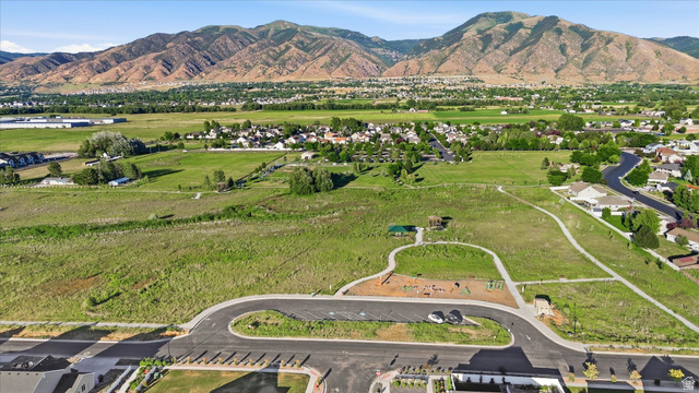 2257 South 1090 West, Unit 74 Nibley, UT 84321 - Photo 40 of 40 Expansive undeveloped land featuring a paved roadway, a dedicated parking area, and a recreational space with play equipment