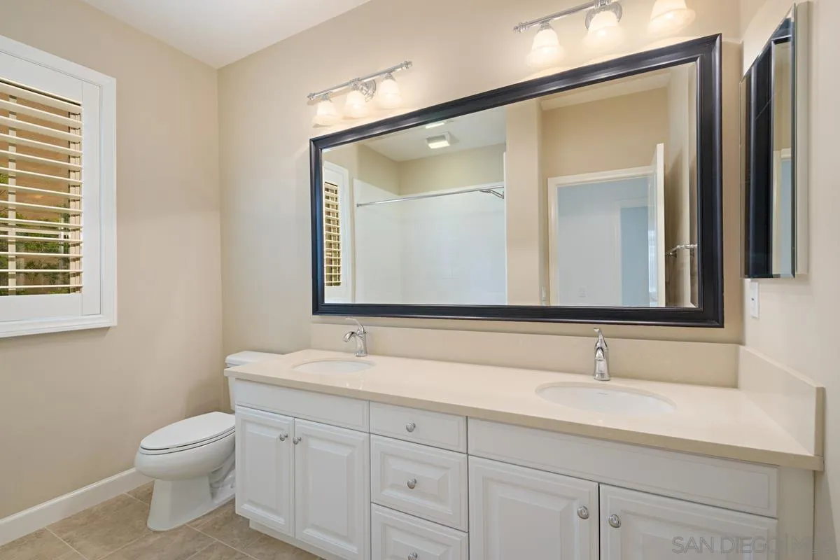 82 Brindisi Irvine, CA 92618 - Photo 28 of 49 a bathroom with a toilet a sink a vanity and mirror