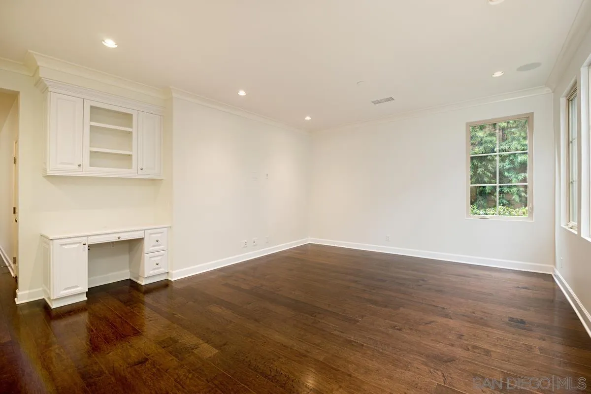 82 Brindisi Irvine, CA 92618 - Photo 9 of 49 an empty room with wooden floor a fireplace and windows