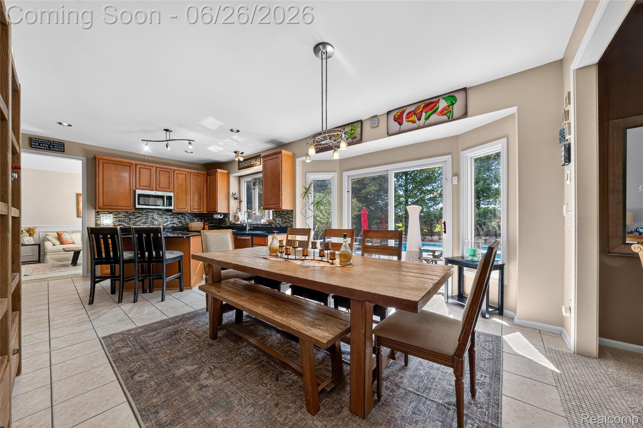 2619 Lambeth Park Rochester, MI 48306 - Photo 25 of 71 Open-concept living space with large sliding glass doors, recessed lighting, tile flooring, a kitchen with wood cabinetry and dark countertops, and an adjacent living area