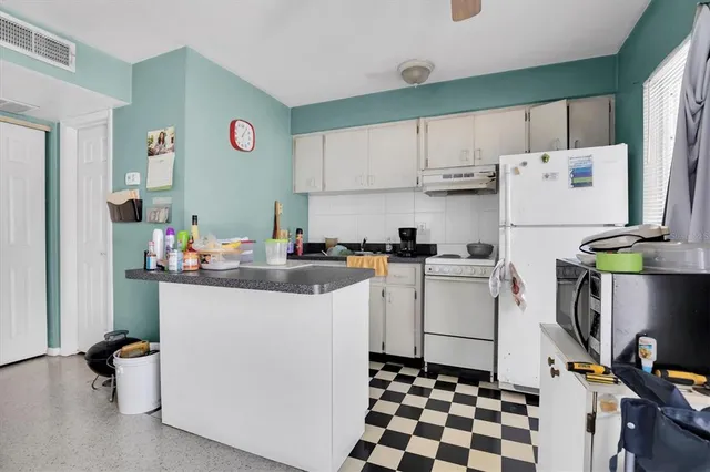 a kitchen with a refrigerator and a sink