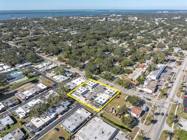 an aerial view of a residential houses with outdoor space and trees