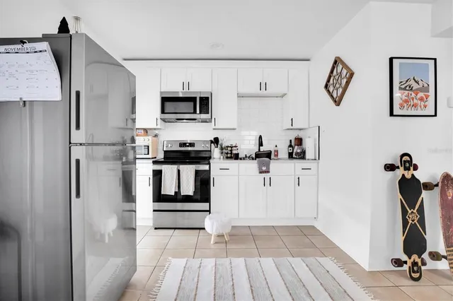 a kitchen with white cabinets and stainless steel appliances