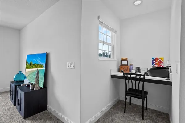 a view of a workspace with furniture and a window