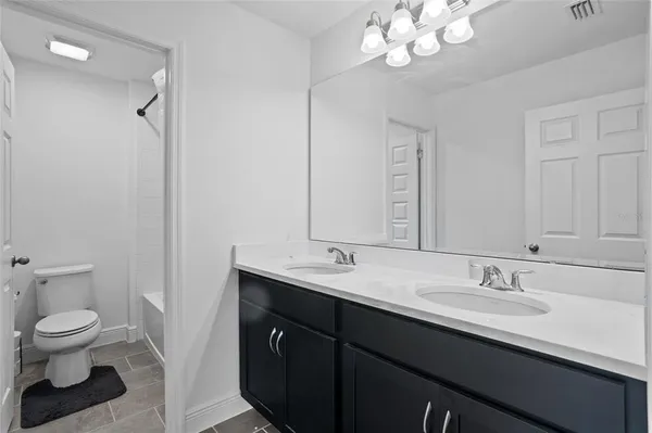 a bathroom with a granite countertop sink a toilet and a mirror