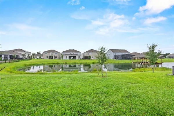 a view of a green field with house in the background