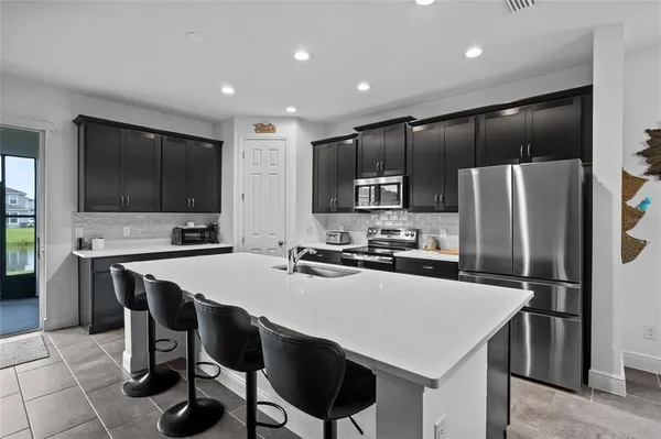 a kitchen with stainless steel appliances a stove a sink a microwave a refrigerator and cabinets