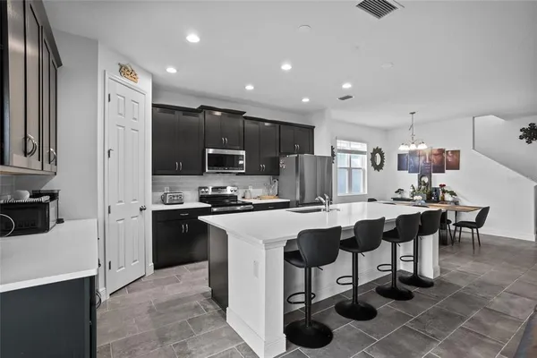 a kitchen with stainless steel appliances a stove a sink a microwave a refrigerator and cabinets