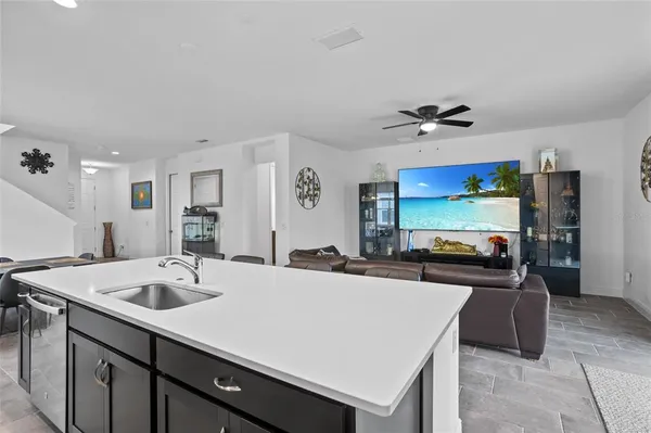 a kitchen with stainless steel appliances a sink a stove a refrigerator a center island and a refrigerator