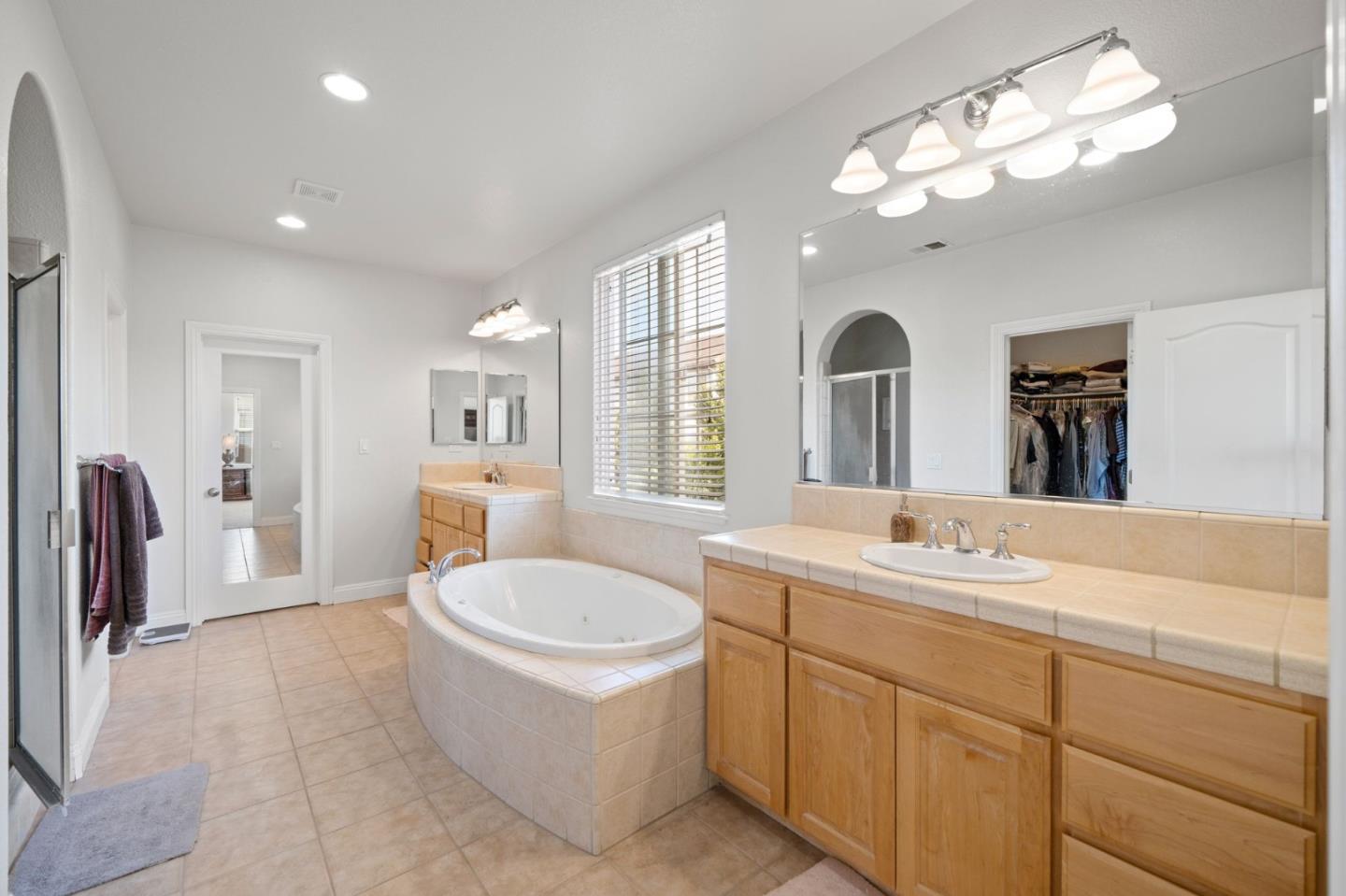 318 Rothbury Way San Ramon, CA 94582 - Photo 34 of 53 a spacious bathroom with a granite countertop sink a mirror a bathtub and shower