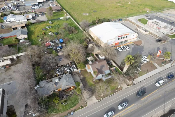 a front view of a house with a yard and wooden fence