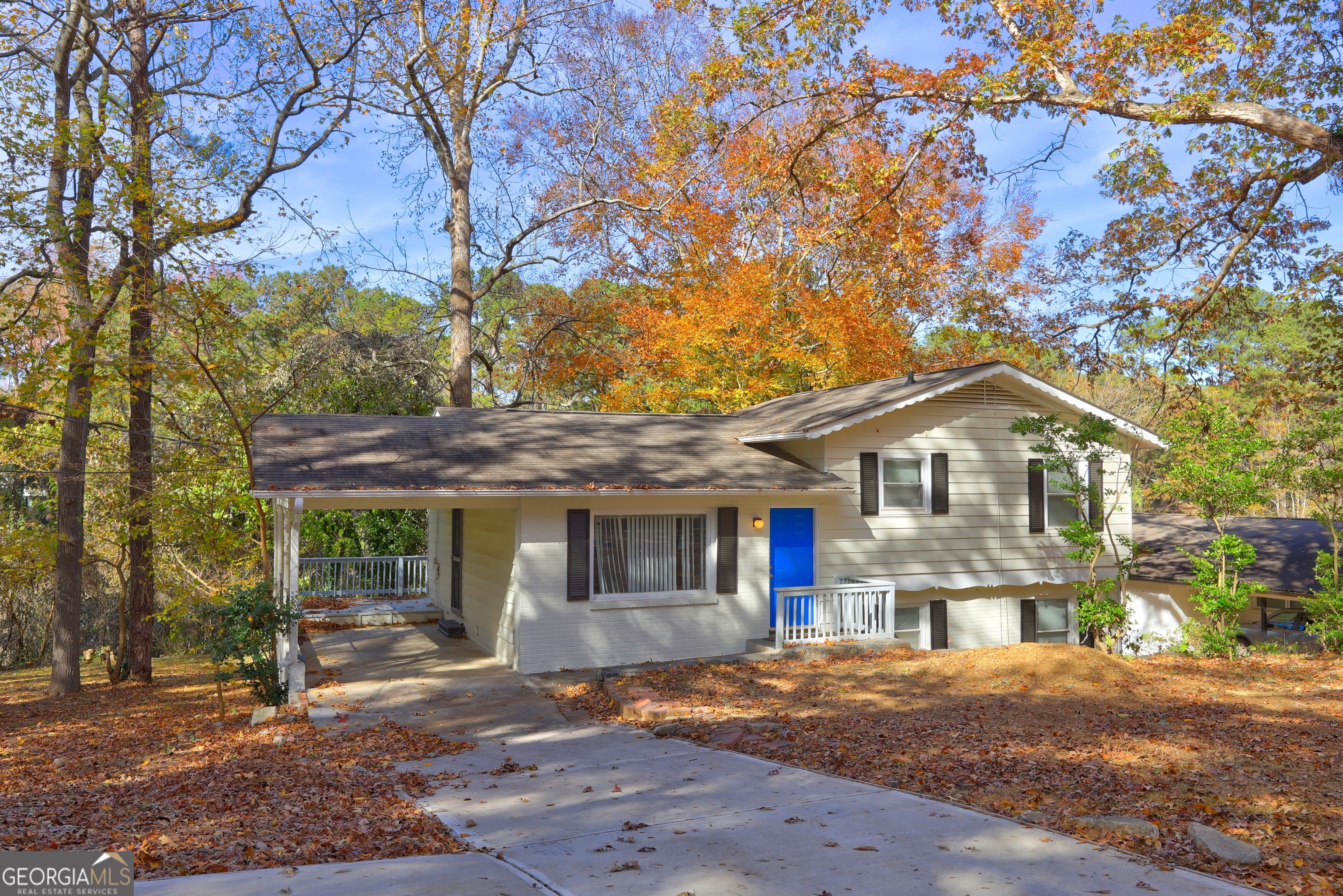 a front view of a house with a yard and large tree