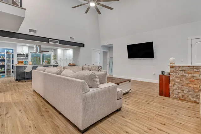 a dining area with stainless steel appliances kitchen island granite countertop a dining table chairs and view living room