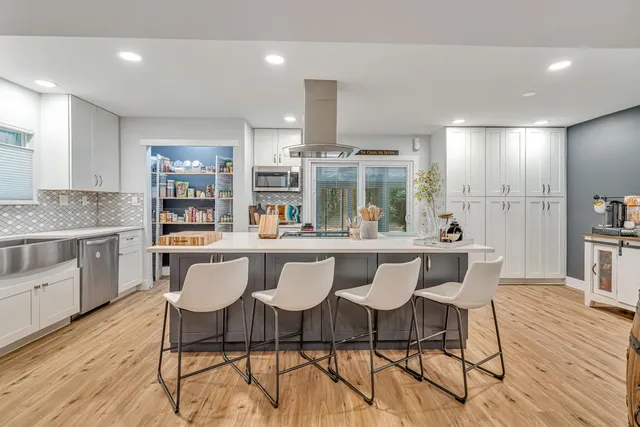 a kitchen with white cabinets and stainless steel appliances