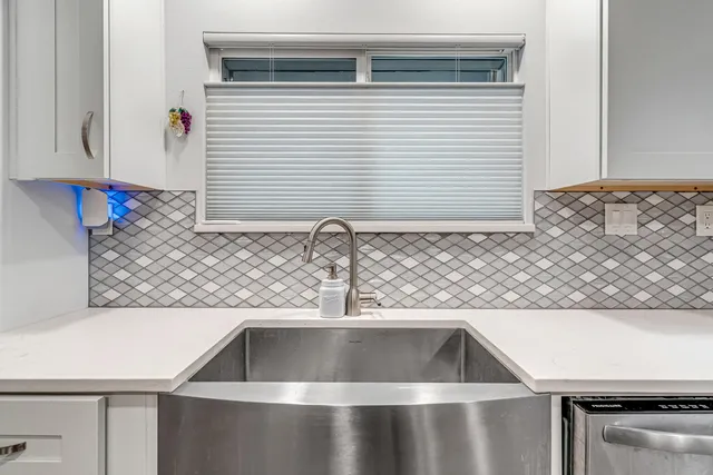 a room with kitchen island a wooden floor and white appliances