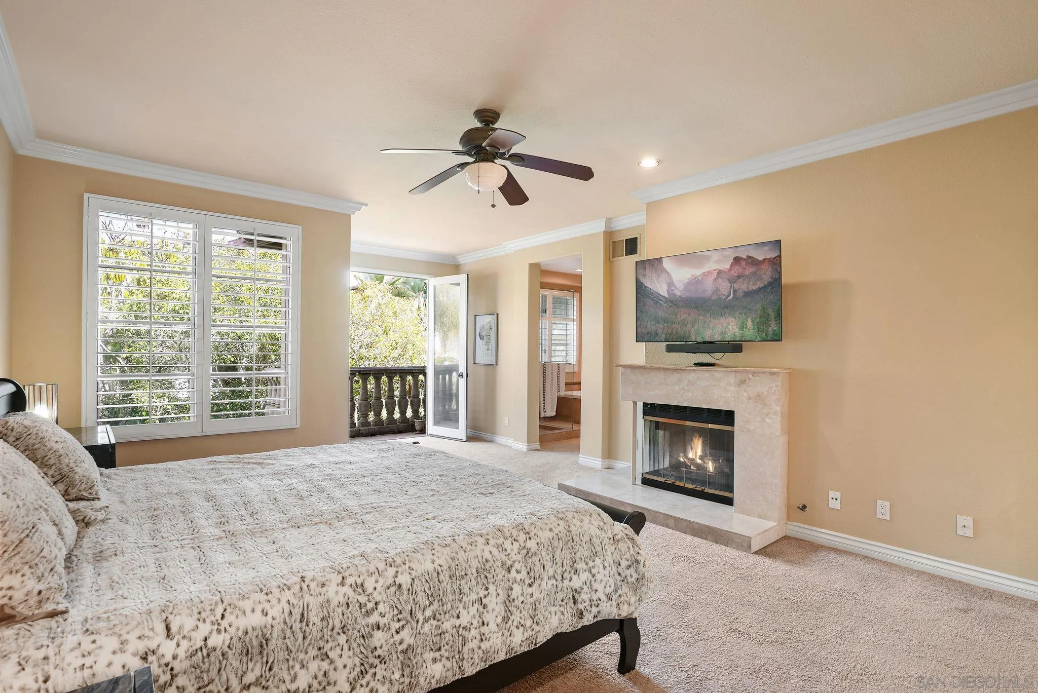9683 Claiborne Square La Jolla, CA 92037 - Photo 33 of 67 a bedroom with a bed and a fireplace