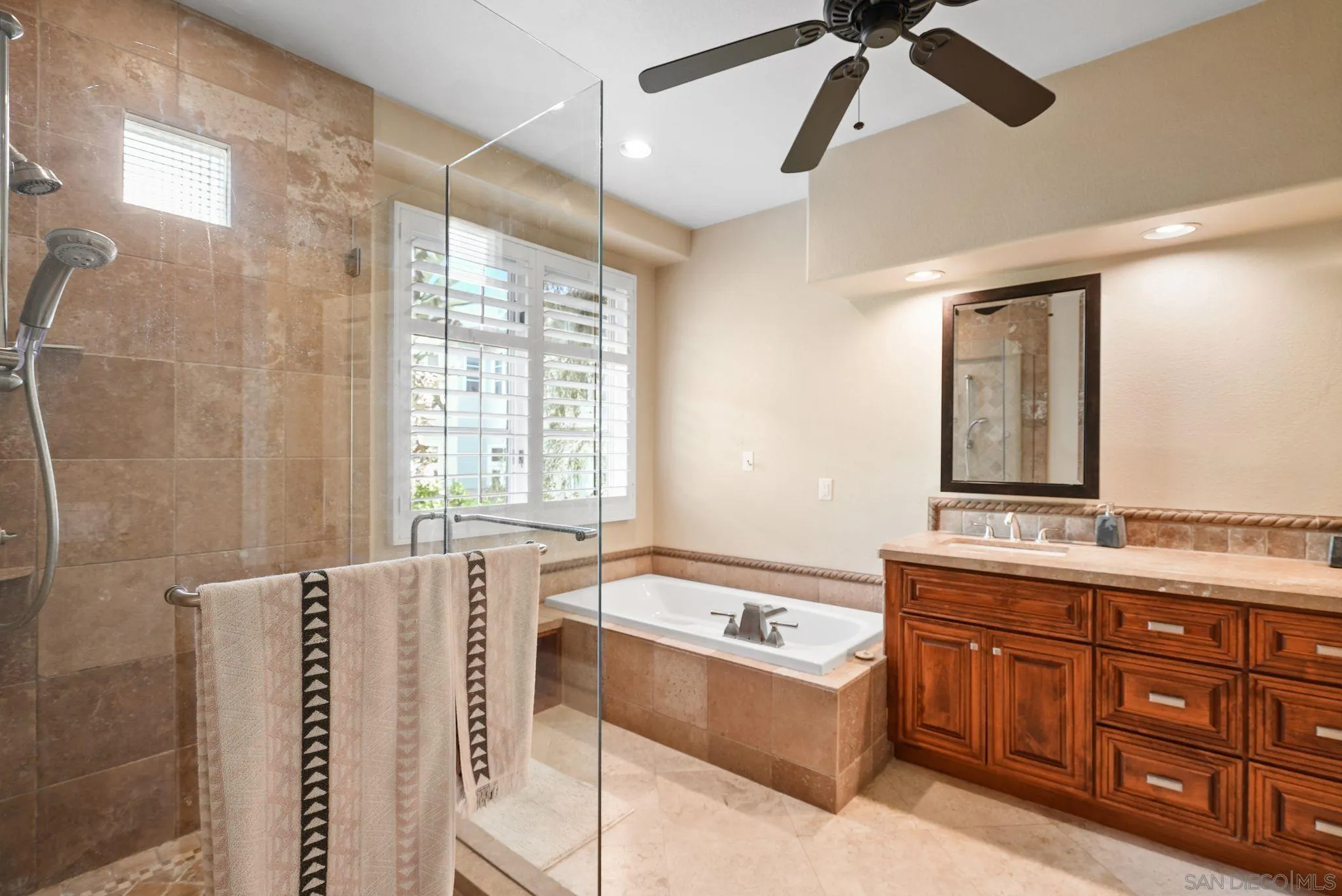 9683 Claiborne Square La Jolla, CA 92037 - Photo 37 of 67 a spacious bathroom with a granite countertop tub sink and mirror